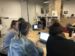 Formation en cours sur l'édition dans Wikipédia. Plusieurs personnes regardent une qui présente sur son ordinateur portable.