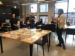 Présentation de Julie Ravary devant un groupe de gens, elle parle de documents qui sont disposés devant elle sur une table dans la salle de lecture d'Artexte.