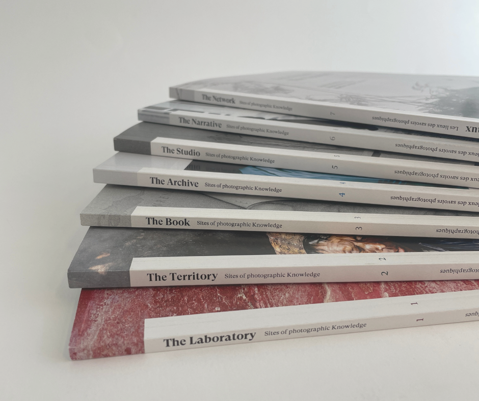 Photographie couleur format carré de sept petits livres empilés en éventail.