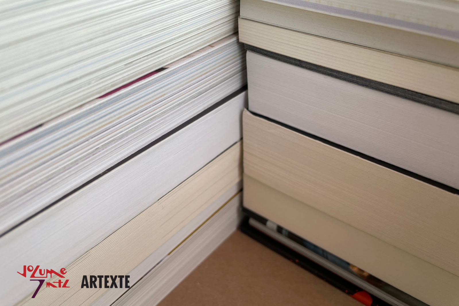 Square-format colour photograph of a close-up of two stacks of books forming a corner.