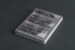 Black and white photograph of the back cover of a book, on which a folded artwork is attached.