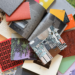 Colour photograph showing numerous photobooks of various shapes and colours piled on top of each other in an artistic way.